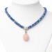 Close-up of blue beaded Kumihimo necklace with silver clasp and rose quartz stone, handcrafted statement necklace